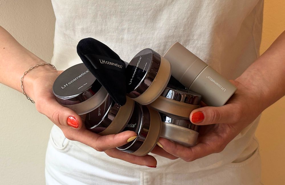 holding multiple loose powder containers, powder puff and mini setting spray with orange nail polish