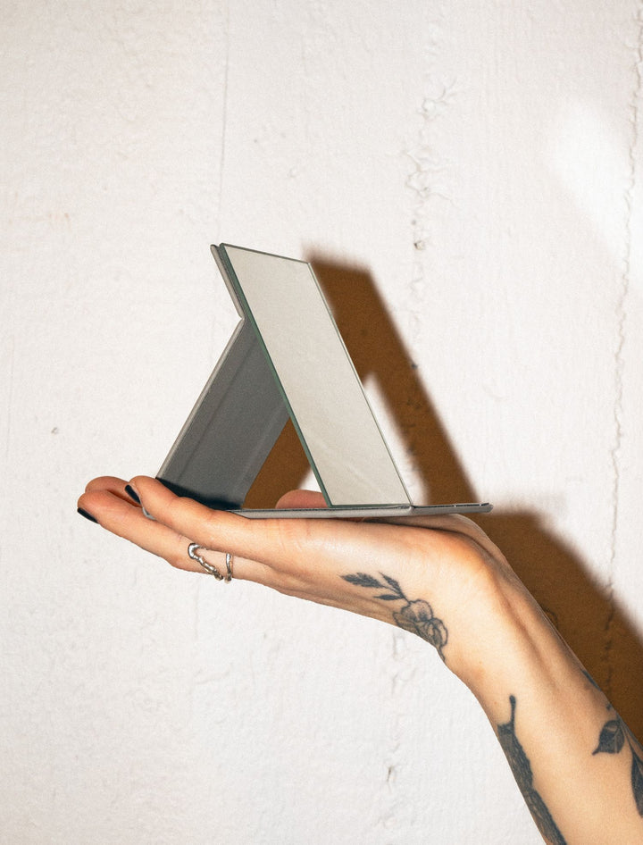 Hand holding pocket mirror